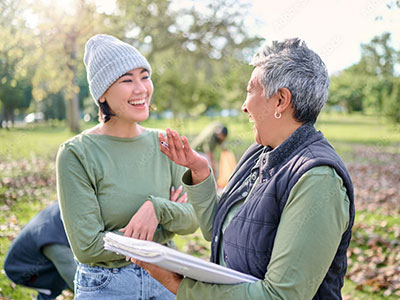 Volunteer leader holding a clipboard and speaking with a woman